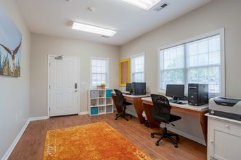 A room with a white door, a yellow door, and a desk with a computer and printer
